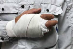 An injured hand held to chest